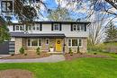 Two-story residence featuring light-colored siding and stone veneer accents