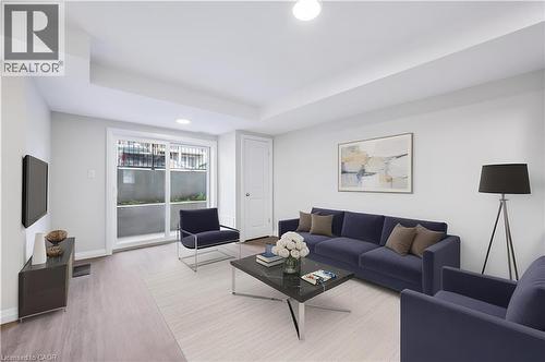 Living room featuring wood finished floors, recessed lighting, and a raised ceiling