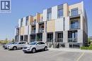 Modern townhome exteriors featuring horizontal light-toned siding, dark grey paneling, and white facade accents