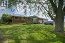 Brick exterior residence featuring a metal roof and a spacious front lawn