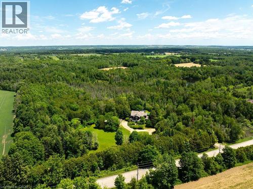 Extensive treed landscape with a visible road and a private residence