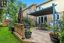 Expansive multi-level wood deck featuring a covered outdoor dining area and sliding glass doors