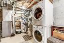 Dedicated utility area featuring a stacked washer and dryer, water heater, and furnace system, 100 amp service