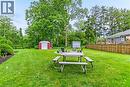community area with expansive green lawn, mature trees and a wood picket fence
