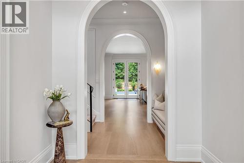 Archway entry featuring light wood-finish flooring, recessed lighting, and white trim