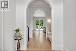 Archway entry featuring light wood-finish flooring, recessed lighting, and white trim