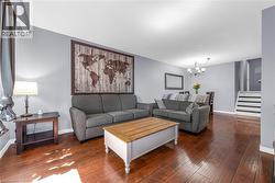 Open-concept living space featuring wood-finish flooring, light grey wall paint, and white trim