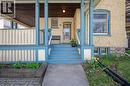 Covered front porch with blue-painted railing and columns