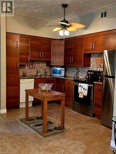 Full kitchen featuring rich wood-finish cabinetry and granite-style countertops