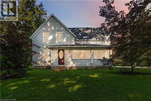 Traditional two-story residence with a covered front porch featuring white columns and latticework