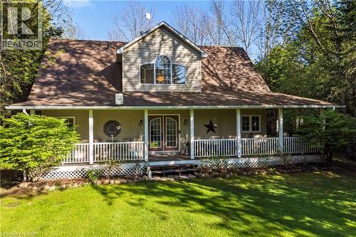 Expansive front porch with white railings and lattice skirting, featuring double glass-paneled entry doors