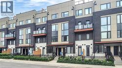 Modern townhouse exterior featuring a multi-tone facade with dark brick and light-colored panels