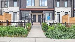 Contemporary townhome featuring a dark brick facade and light-colored stone accents
