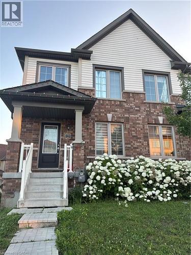 Brick and siding exterior featuring a covered porch entry