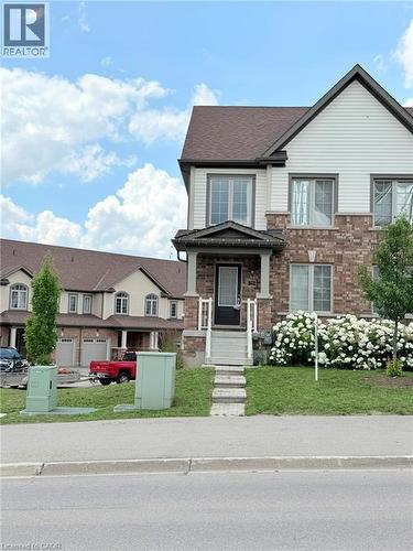 Contemporary townhome featuring a brick and siding facade, covered porch entry, and a prominent front door