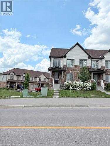 Multi-story townhouse exterior featuring a brick and siding facade