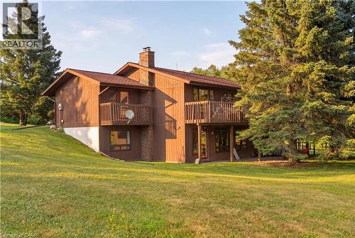 Two-story exterior with wood siding, multiple balconies, and a chimney feature