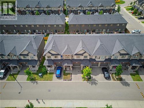 Modern townhome community featuring uniform dark gray roofs and light-toned siding