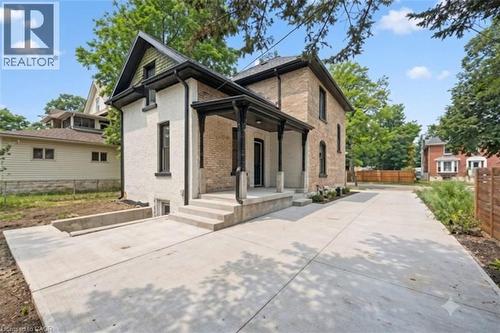 Concrete patio area featuring a covered porch with black columns.