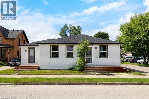 Charming single-story residence featuring white vinyl siding, a dark composition roof, and a welcoming front entrance with a covered porch