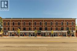 Brick exterior commercial building with multiple storefronts and upper-level windows
