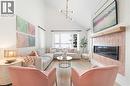 Vaulted ceiling living area featuring light wood-finish flooring, a contemporary linear fireplace with a textured pink tile surround, and a natural wood mantel