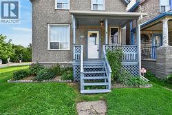 Front porch with wood-finish railing, steps, and latticework