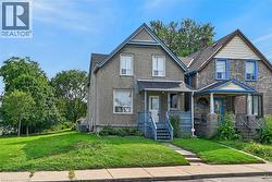 Two-story residence with a covered front porch featuring a lattice railing, a peaked gable roof, and a paved walkway leading to the entrance