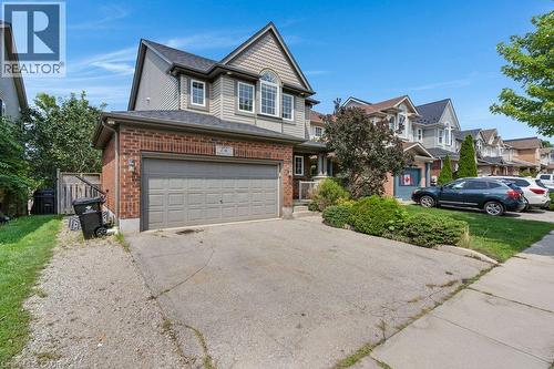 Brick and siding exterior with an attached garage and a paved driveway