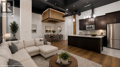 Open-concept living space with dark wood-finish cabinetry, stainless steel appliances, and a central island
