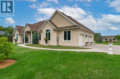 Stucco exterior with arched entryways, multiple gabled rooflines, a multi-car garage, and a curved paved driveway