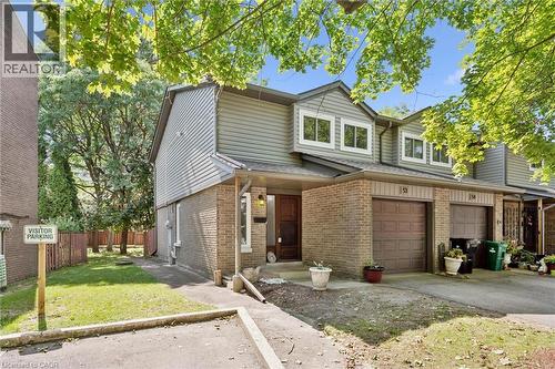 Brick and siding exterior featuring an integrated garage, front entry, and multiple windows