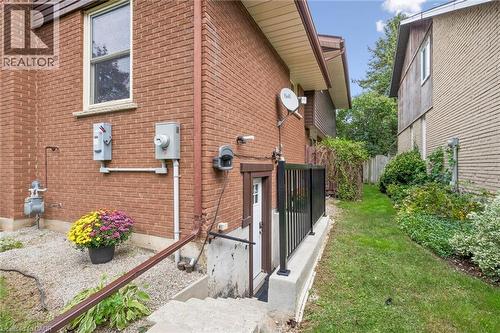 Brick exterior with a side entrance and concrete steps leading to a lower level