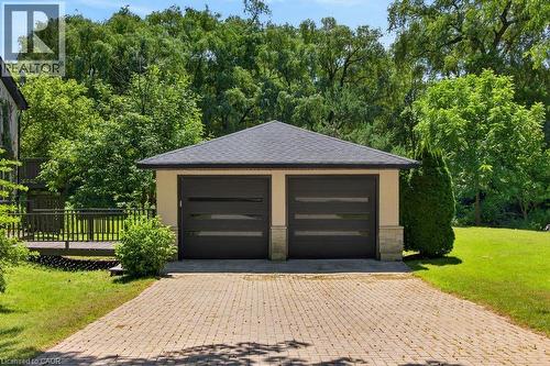 Detached two-car garage featuring modern dark-paneled doors with horizontal frosted glass inserts