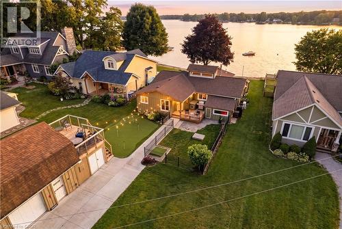 Waterfront property featuring a private putting green, expansive lawn, and direct lake access