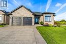 Stone and solid brick exterior, oversize garage with window inserts, exposed  aggregate driveway,manicured lawn