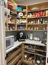 Corner pantry with wood-finish shelving, light-toned countertops, and pull-out drawers