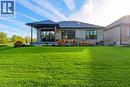 Expansive green lawn with mature landscaping, large low 