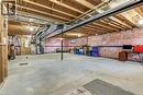 Unfinished basement with exposed ceiling joists, concrete flooring, and visible insulation along perimeter walls