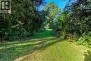 Expansive green lawn surrounded by mature trees and lush foliage