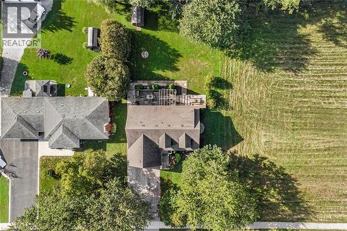 Expansive property featuring a paved driveway, a large detached garage, and a spacious backyard with mature trees