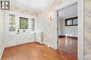 Wood-finish flooring with a carpeted staircase and ornate newel post