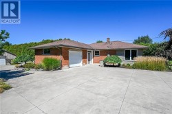 Brick and stone exterior featuring an attached garage and a concrete driveway