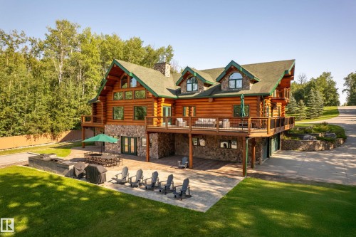 The backside of this home is truly spectacular. It looks out towards the lake and you have easy access to your walkout basement summer kitchen as well as your amazing grill area. Home features a bocce ball court, firepit and dock.