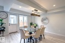 Dining room with recessed lighting, light wood finished floors, and a tray ceiling