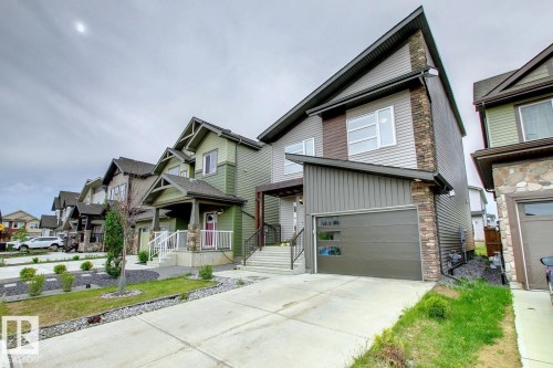 View of front of home featuring board and batten siding, stone siding, concrete driveway, and a garage