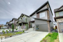 View of front of home featuring board and batten siding, stone siding, concrete driveway, and a garage