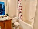 Full bath featuring shower / bath combo with shower curtain, vanity, and tile patterned floors