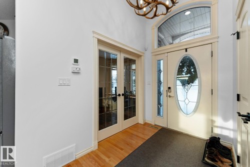 Entrance foyer with french doors, plenty of natural light, a chandelier, and a towering ceiling