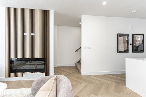 Living area with a glass covered fireplace, recessed lighting, stairway, and a textured ceiling